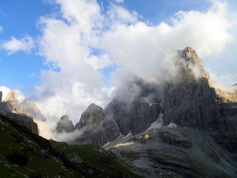 Primera visión  - Envuelto en nubes, la primera pared de la derecha es la cara noreste del Crozzon, su espolón y recibiendo los vespertinos rayos del sol, su pared oeste.
A su izquierda, el Canalone Neri, el corredor que lo separa de la cima Tosa, escondida tras las nubes.
Bajo a la izquierda se aprecia la silueta de la pequeña capilla que hay junto al refugio Brentei. 